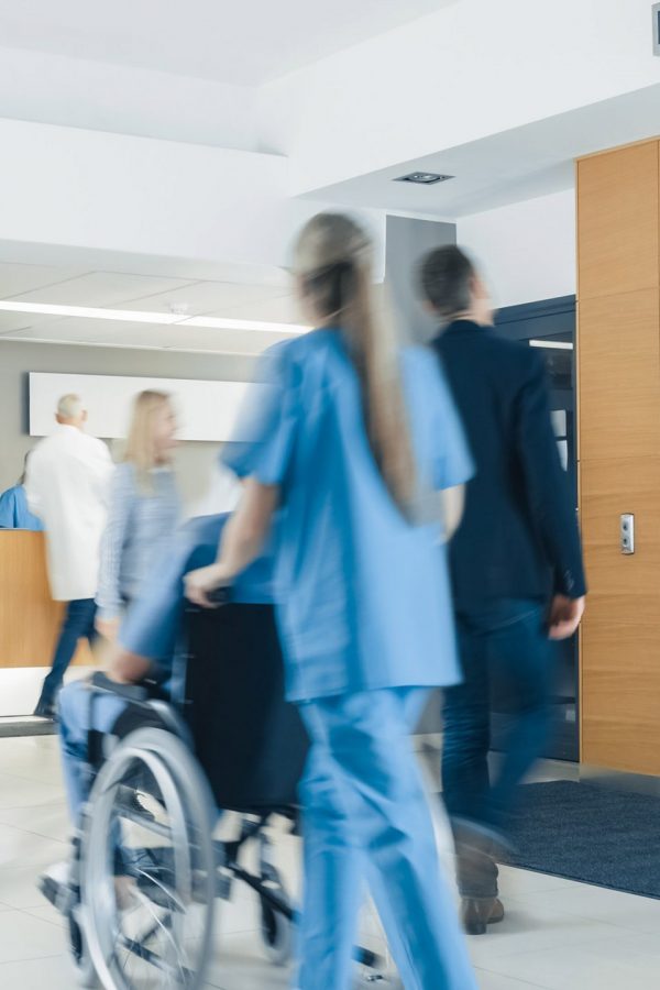 Hospital Lobby. Doctors, Nurses, Assistant Personnel and Patients Working and Walking in the Lobby of the Medical Facility.
